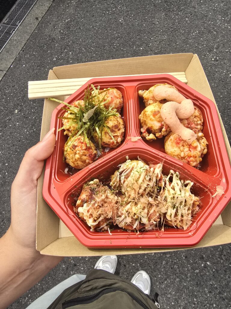 bandeja dividida con takoyaki surtido (tradicionales bolitas de pulpo japonesas), un plato emblemático de la gastronomía callejera de Osaka, del popular establecimiento Takoyaki Juhachiban.