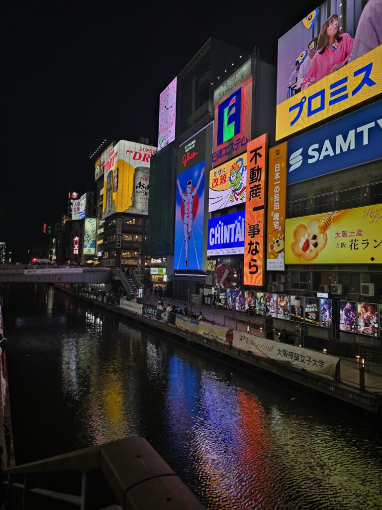 Letrero luminoso del Glico Man en el canal de Dotonbori iluminado de noche en Osaka, Japón.