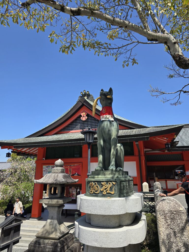 estatua de un zorro (kitsune) con una espiga de arroz en la boca, ubicada en el famoso santuario Fushimi Inari-taisha en Kioto, Japón.