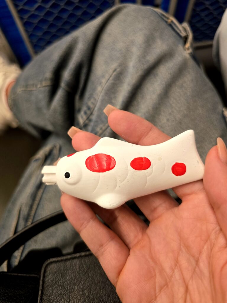 amuleto de papel de la suerte u oráculo en forma de carpa koi (Koi Omikuji), originario de la Santuario Hiroshima Gokoku en Japón
