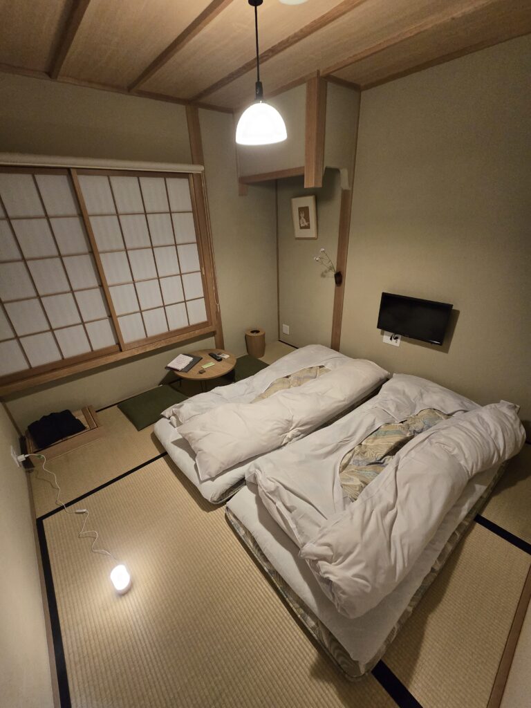 habitación tradicional japonesa (o washitsu) con suelo de tatami y camas futon extendidas sobre el suelo en un Ryokan