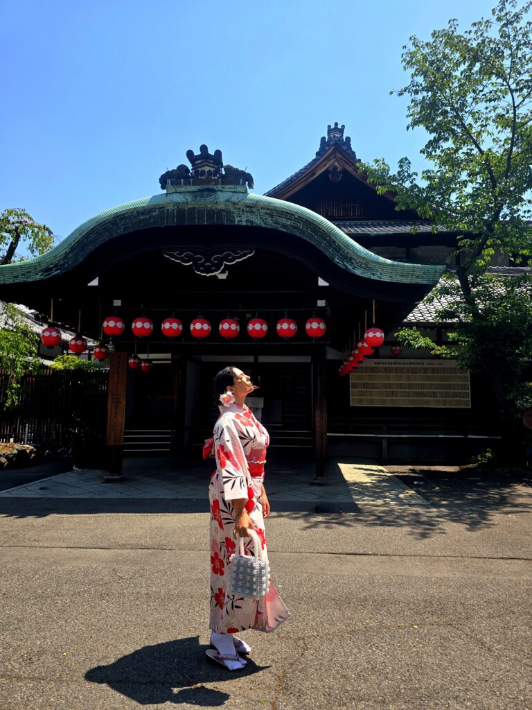 una persona con un kimono tradicional posando frente al Gion Corner en el histórico distrito de Gion en Kioto, Japón, un emblemático centro cultural conocido por albergar espectáculos de artes escénicas tradicionales.