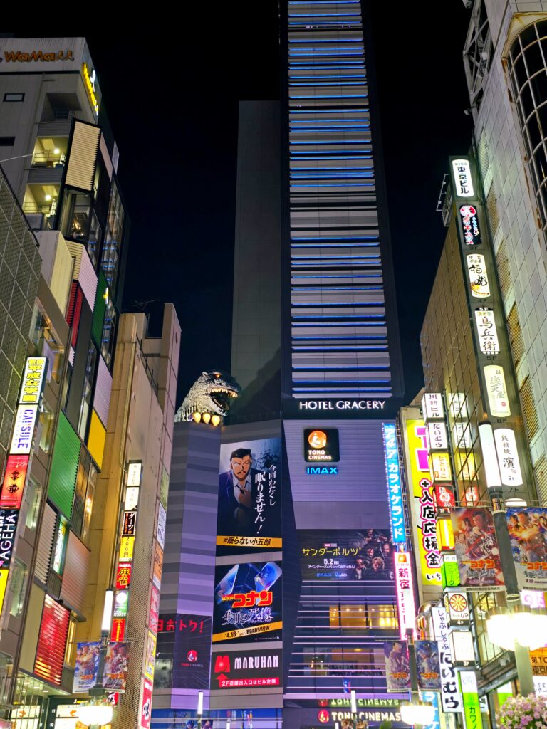 la famosa cabeza gigante de Godzilla asomándose desde el edificio del Hotel Gracery Shinjuku y los cines Toho en Tokio, Japón
