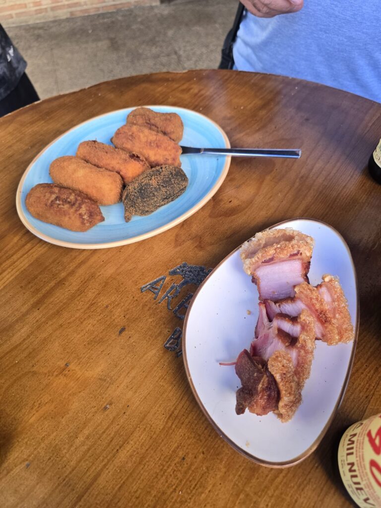 Plato de croquetas artesanas y torrezno de Soria crujiente servidos en un bar tradicional.
