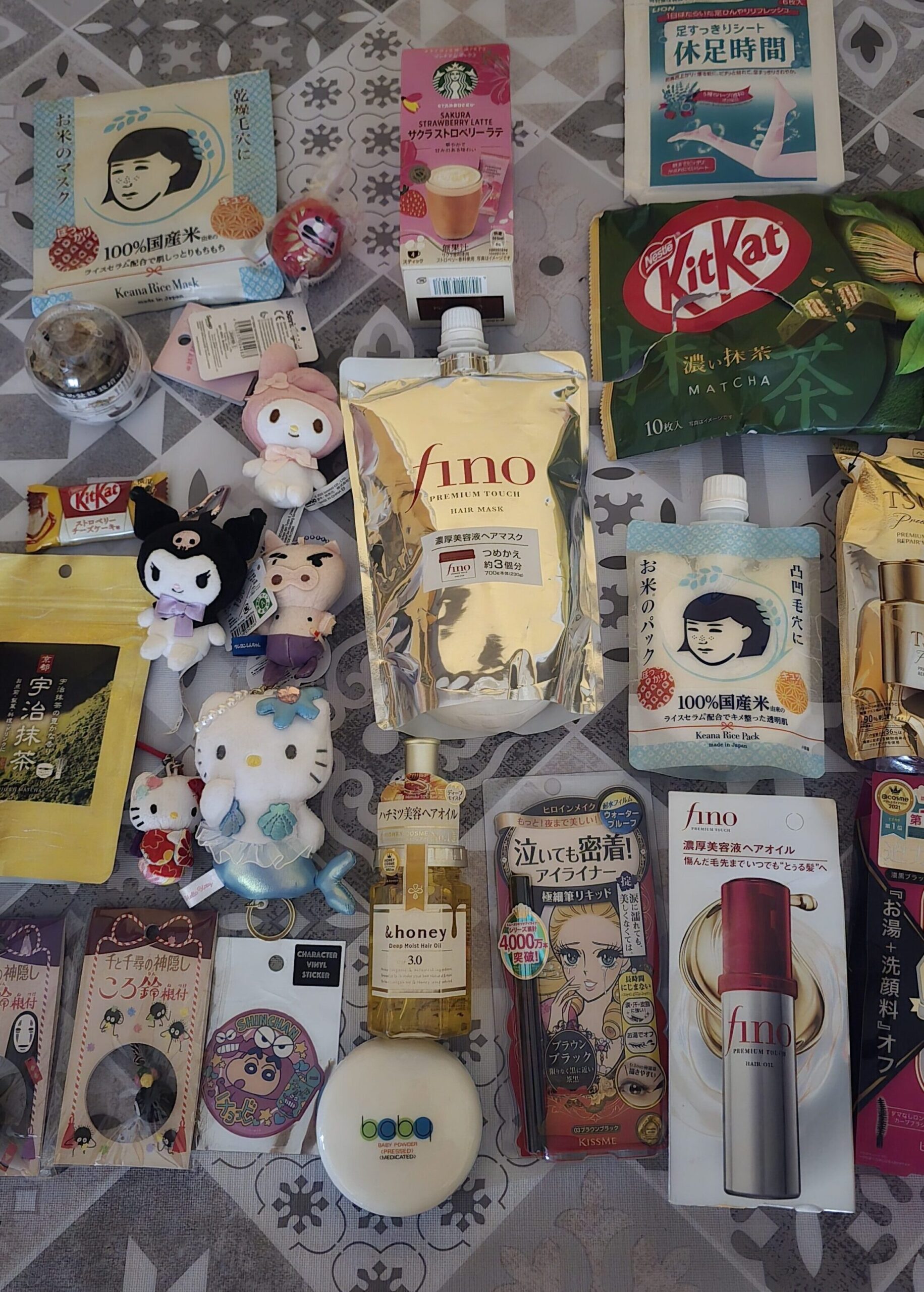 Productos de belleza japoneses, dulces KitKat de matcha y peluches de Hello Kitty y Kuromi comprados como suvenires en un viaje a Tokio.
