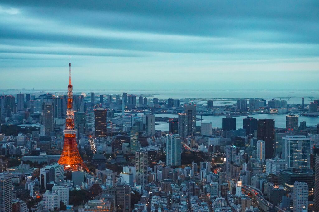 Torre de Tokio iluminada de color naranja brillante en medio del paisaje urbano de la capital de Japón